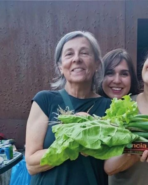 Mónica de Blas sonríe con una brazada de acelgas y lechugas recién cortadas